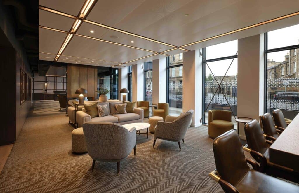 Large open communal area of The Resident Edinburgh with comfortable seating and Gilberts grilles in the ceiling