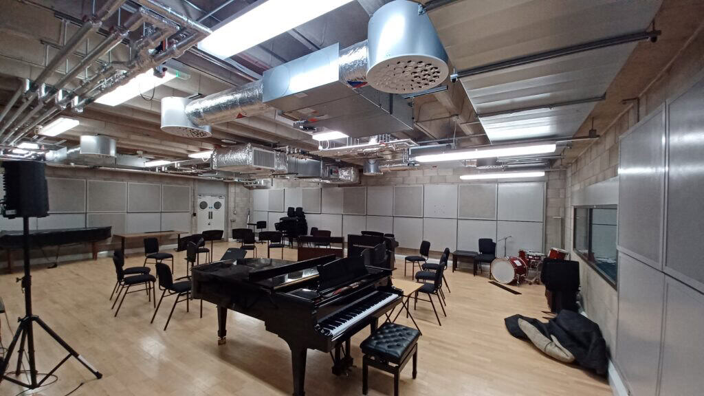 Music room with a black piano centre. Gilberts Multi Nozzle diffuser in the ceiling.