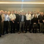 A group photo of the sales, marketing and leadership team stood in the meeting room at Boulevard Hotel