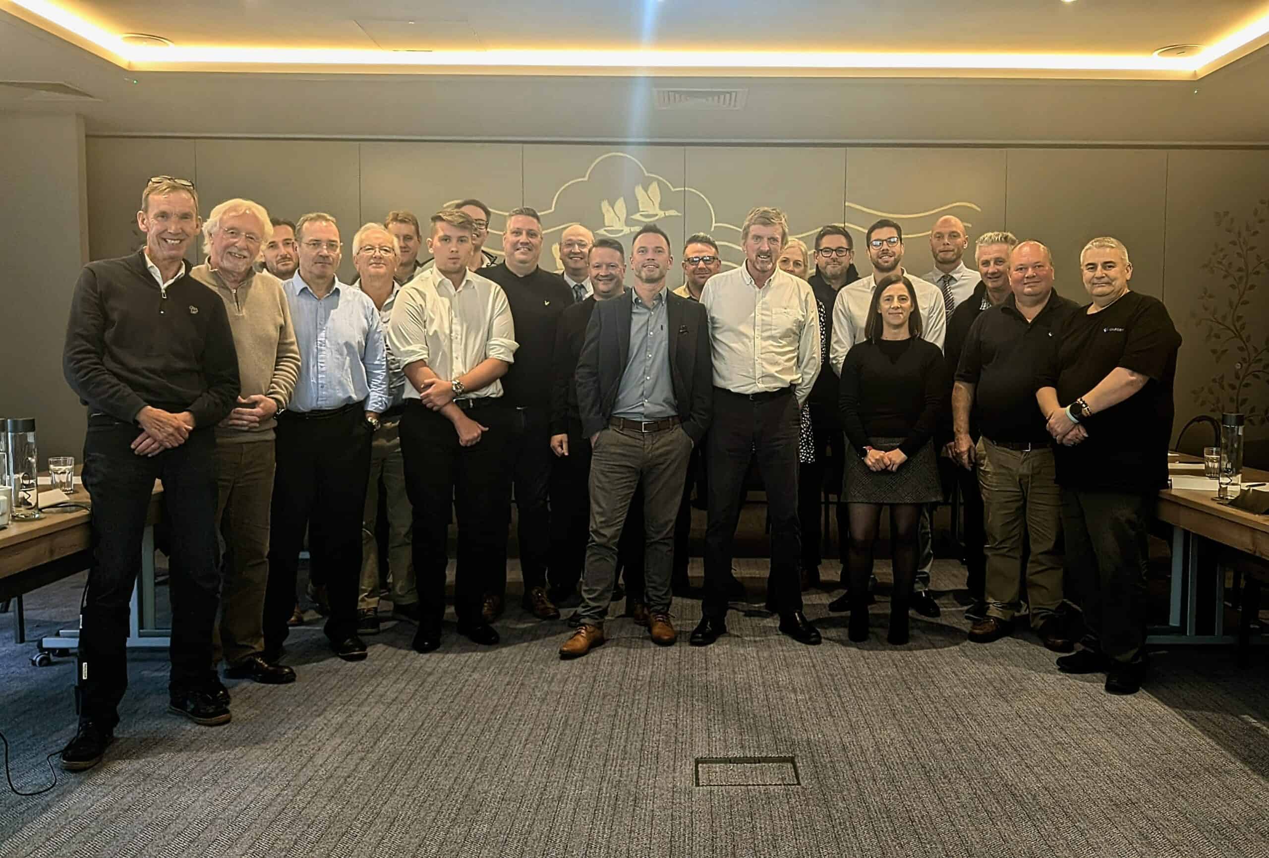 A group photo of the sales, marketing and leadership team stood in the meeting room at Boulevard Hotel