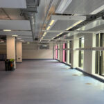 Naturally lit empty corridor in Sheffield Hallam University with floor diffusers running next to the windows